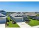An elevated view of a single-story home featuring a lush green lawn and manicured tropical landscaping at 11021 Blue Magnolia Ln, Parrish, FL 34219