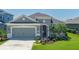 Inviting single-story home featuring a gray color scheme and attractive landscaping at 11021 Blue Magnolia Ln, Parrish, FL 34219