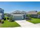 Charming single-story home with a well-manicured lawn and tropical landscaping at 11021 Blue Magnolia Ln, Parrish, FL 34219