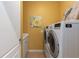 Functional laundry room with modern washer and dryer, storage cabinet, and bright decor at 11021 Blue Magnolia Ln, Parrish, FL 34219