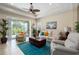 Living room with ceiling fan, tile floors, large sliding glass doors to lanai and neutral decor at 11021 Blue Magnolia Ln, Parrish, FL 34219