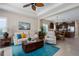 Comfortable living room with open view to the kitchen, a ceiling fan and lots of natural light at 11021 Blue Magnolia Ln, Parrish, FL 34219