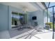 Screened-in patio area perfect for relaxing, featuring comfortable seating and a ceiling fan at 11021 Blue Magnolia Ln, Parrish, FL 34219