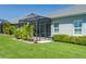 A backyard view featuring a screened-in lanai and lush tropical landscaping for privacy at 11021 Blue Magnolia Ln, Parrish, FL 34219