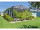 Backyard view featuring a screened-in patio with lush tropical landscaping providing backyard privacy at 11021 Blue Magnolia Ln, Parrish, FL 34219