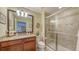 Well-lit bathroom featuring a glass-enclosed shower and a granite-topped vanity at 11176 Roseate Ct, Sarasota, FL 34238