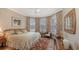 Comfortable bedroom with bright natural light from bay windows, patterned curtains, and a plush rug at 11176 Roseate Ct, Sarasota, FL 34238
