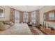 Comfortable bedroom with bright natural light from bay windows, patterned curtains, and a plush rug at 11176 Roseate Ct, Sarasota, FL 34238