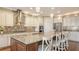 Bright kitchen featuring a large granite island with bar seating, stainless steel appliances, and tiled backsplash at 11176 Roseate Ct, Sarasota, FL 34238
