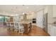 Bright kitchen featuring a large granite island with bar seating, stainless steel appliances, and hardwood flooring at 11176 Roseate Ct, Sarasota, FL 34238