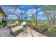 Relax on the lanai with comfortable lounge chairs, vibrant plants, and a tranquil view of the picturesque lake at 11176 Roseate Ct, Sarasota, FL 34238