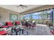 Enjoy outdoor dining with serene lake views from this screened lanai with comfortable seating and charming decor at 11176 Roseate Ct, Sarasota, FL 34238