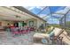 Enjoy outdoor living in this spacious lanai with comfortable seating, a dining area, and views of the lush landscape at 11176 Roseate Ct, Sarasota, FL 34238