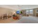 Bright living room with comfortable couches, a ceiling fan, and large windows with floral curtains at 11176 Roseate Ct, Sarasota, FL 34238