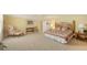 Spacious bedroom with a queen bed, bedside tables, and a cozy seating area with a pink chair at 11176 Roseate Ct, Sarasota, FL 34238