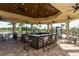 Spacious outdoor kitchen area with bar seating, ceiling fans, and views of the pool at 11176 Roseate Ct, Sarasota, FL 34238