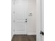 Neutral entryway featuring a white door, dark floors, and a smart thermostat at 11214 Sandhill Preserve Dr, Sarasota, FL 34238