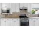 Modern kitchen features stainless steel appliances, granite countertops, and white cabinetry at 11214 Sandhill Preserve Dr, Sarasota, FL 34238