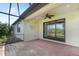 Screened lanai with a ceiling fan and backyard views through sliding glass doors at 11214 Sandhill Preserve Dr, Sarasota, FL 34238
