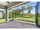 Enclosed lanai with brick floors and views of the landscaped backyard and mature trees at 11214 Sandhill Preserve Dr, Sarasota, FL 34238
