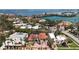 An aerial view of a luxurious waterfront home surrounded by lush tropical landscaping with a beautiful red tile roof at 113 Fillmore Dr, Sarasota, FL 34236