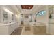 Luxurious bathroom featuring a double vanity, soaking tub, and arched windows for natural lighting at 113 Fillmore Dr, Sarasota, FL 34236