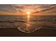 Beautiful sunset view of the ocean with warm color skies and ocean waves washing up on the shoreline at 113 Fillmore Dr, Sarasota, FL 34236
