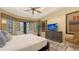 Well-lit bedroom with large windows, neutral walls, and a view of the outdoor garden and patio at 113 Fillmore Dr, Sarasota, FL 34236
