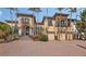 Elegant two-story home with a brick driveway, grand staircase, three car garage, and manicured landscaping at 113 Fillmore Dr, Sarasota, FL 34236