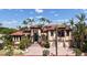 A stunning two-story home featuring a red tile roof, arched windows, and lush tropical landscaping at 113 Fillmore Dr, Sarasota, FL 34236