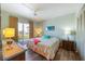 Bright bedroom with balcony access featuring a queen-size bed and matching wood furnishings at 117 7Th N St # 35, Bradenton Beach, FL 34217