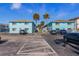 Two-story light blue building with tan roof, ample parking, and blue skies at 117 7Th N St # 35, Bradenton Beach, FL 34217