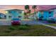 Exterior view of the blue apartment complex with cars parked in front, surrounded by lush landscaping at 117 7Th N St # 35, Bradenton Beach, FL 34217