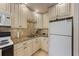 Charming kitchen featuring vintage-style cabinetry and stone countertops and backsplash at 117 7Th N St # 35, Bradenton Beach, FL 34217