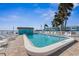 Outdoor community pool with multiple lounge chairs and palm tree landscaping at 117 7Th N St # 35, Bradenton Beach, FL 34217