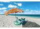 Inviting beach setup with chairs, umbrella, and calm waters, offering a perfect spot for relaxation and coastal enjoyment at 1186 Center Pl, Sarasota, FL 34236