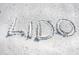 Close-up of 'LIDO' written in the sand, highlighting the idyllic location and inviting atmosphere of the beach at 1186 Center Pl, Sarasota, FL 34236