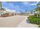 Contemporary home featuring a gravel driveway and beautiful landscaping, complemented by palm trees and vibrant bougainvillea at 1186 Center Pl, Sarasota, FL 34236