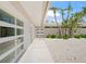 Exterior view showing the home's entrance, with white doors, palm trees, and a gravel landscape at 1186 Center Pl, Sarasota, FL 34236