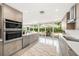 A modern kitchen features stainless appliances and a window wall with an outdoor dining area and patio view at 1186 Center Pl, Sarasota, FL 34236