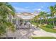 Outdoor dining area with a large table, surrounded by beautiful landscaping and shaded by umbrellas at 1186 Center Pl, Sarasota, FL 34236