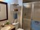 Cozy bathroom featuring a mirrored vanity, shower with sliding glass doors, and metal storage shelves at 1310 Glen Oaks E Dr # 290E, Sarasota, FL 34232