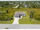 Aerial view of a single-Gathering house with a driveway and landscaped front yard at 13552 Boatbill Ln, Port Charlotte, FL 33981