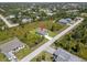An aerial view shows a property surrounded by lush greenery in a residential area at 13552 Boatbill Ln, Port Charlotte, FL 33981