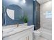 Bathroom featuring modern vanity, marble countertop, blue accent wall, and tiled shower/bath at 13552 Boatbill Ln, Port Charlotte, FL 33981