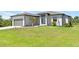 Attractive home with a well-manicured lawn, lush plants, and an attached garage at 13552 Boatbill Ln, Port Charlotte, FL 33981