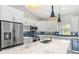 Modern kitchen featuring stainless steel appliances, white cabinets, marble countertops, and stylish pendant lighting at 13552 Boatbill Ln, Port Charlotte, FL 33981