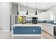Modern kitchen with an island with marble countertop, white cabinets, and stylish lighting fixtures at 13552 Boatbill Ln, Port Charlotte, FL 33981