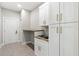 Functional laundry room with built-in cabinets, countertop, sink, and stylish hardware at 13552 Boatbill Ln, Port Charlotte, FL 33981