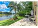Charming patio with an outdoor kitchen, lush green grass, and stunning views of the lake at 1410 Livingston Rd, Lutz, FL 33559